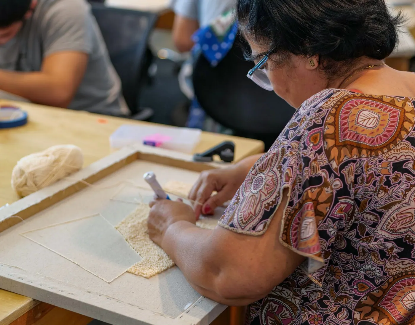Production team working on punch needle panels in the workshop